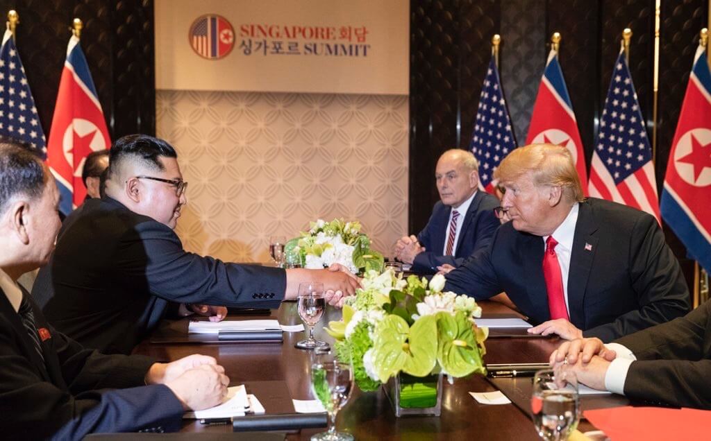 Donald Trump og Kim Jong-Un giver hånd